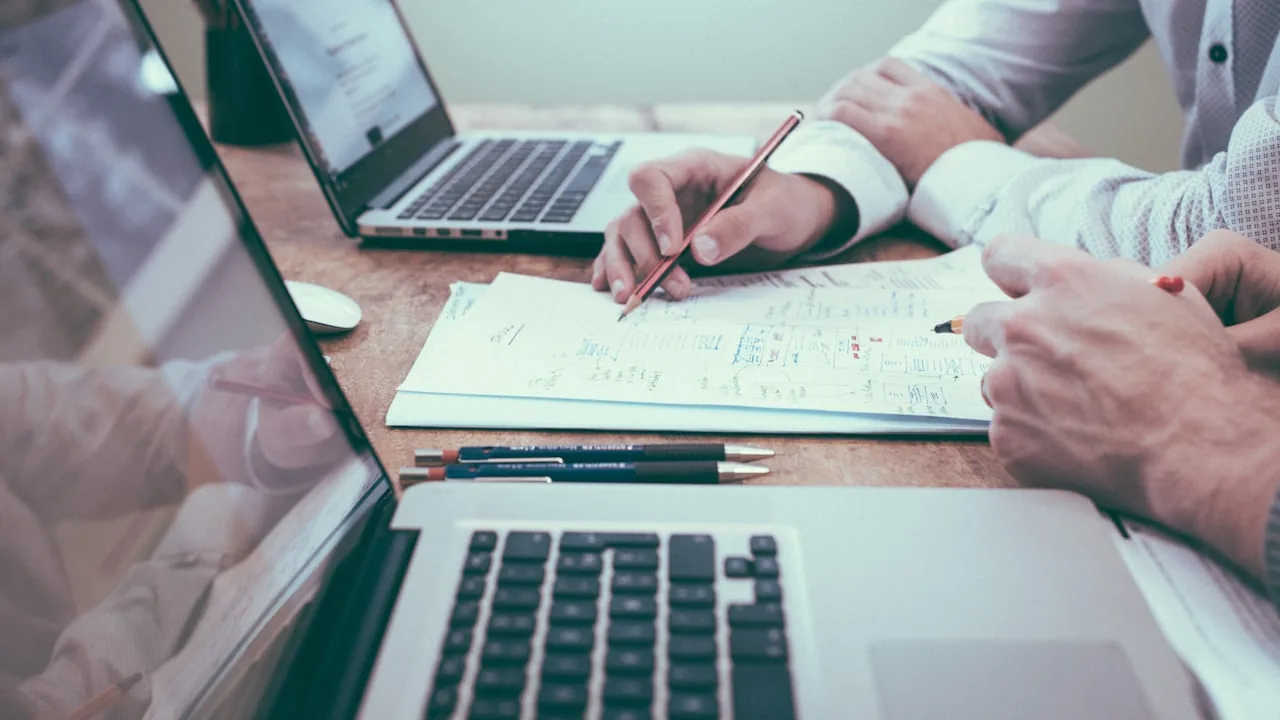 ホームページ制作の外注費用について打ち合わせするビジネスパーソン